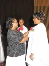 Wedding Day Coordinator, Doris Hunt, pins a corsage on the mother of the bride.